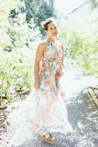 Happy mixed-race japanese woman in romantic floral maxi dress in summer park