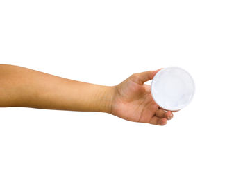 Close-up of hand holding crystal ball against white background