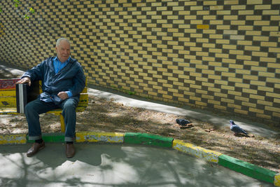 Full length of man sitting on seat