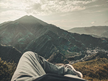 Low section of teenage boy relaxing on mountain