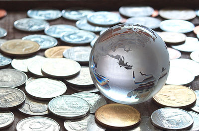 Close-up of globe and coins