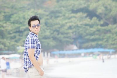 Portrait of boy wearing sunglasses while standing at beach