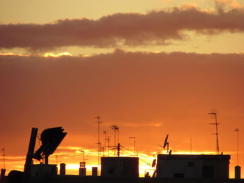 Silhouette of city against sky during sunset