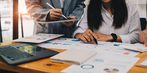 Midsection of business colleagues working on table