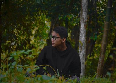 Man looking at camera in forest