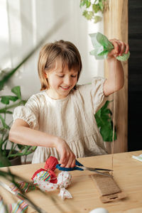 Making easter decorations. a girl makes a textile easter egg at home in the shape of a bunny, bunny
