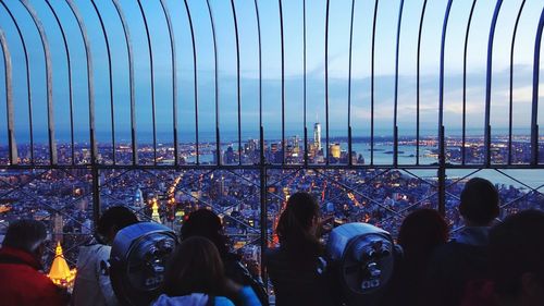 People at observation point against empire state building in city