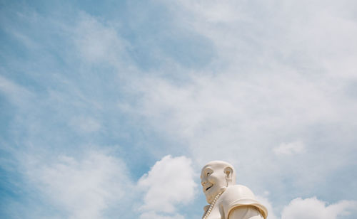 Low angle view of male statue against cloudy sky