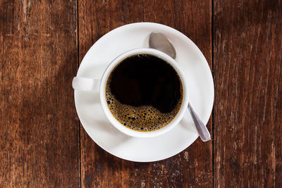 Coffee cup on dark wooden table. top view