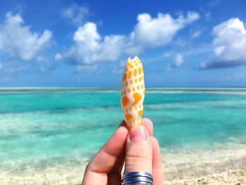 Woman holding ice cream cone on beach