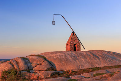 Lighthouse by sea against sky