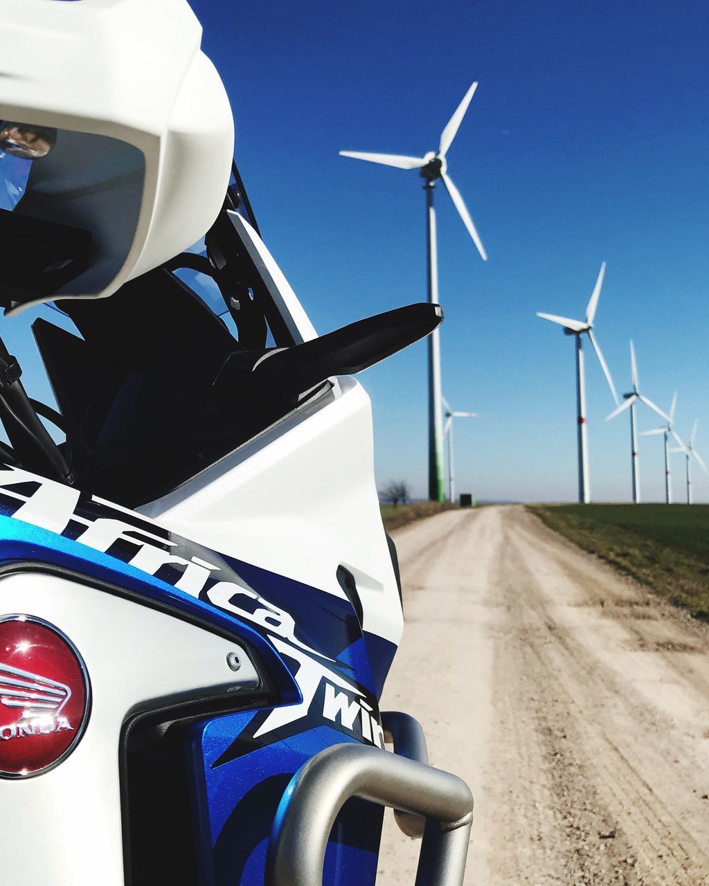 WIND TURBINES ON ROAD AGAINST SKY