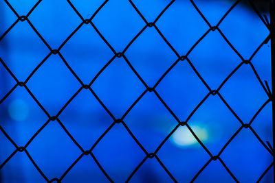 Full frame shot of chainlink fence against blue sky