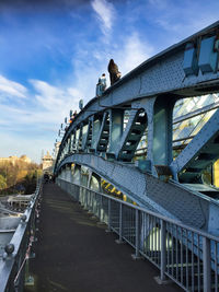 Bridge over road in city against sky