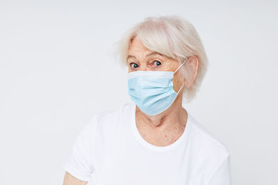 Portrait of woman wearing mask against white background