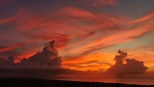 Scenic view of sea against dramatic sky during sunset