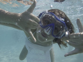 Close-up portrait of woman swimming underwater