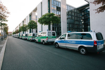 Cars on road by buildings in city