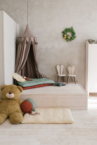 Modern children's room, a tent bed on the podium, soft toys, high chairs in the form of bunnies