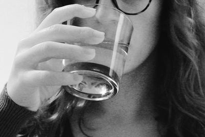 Close-up of woman drinking glass with water