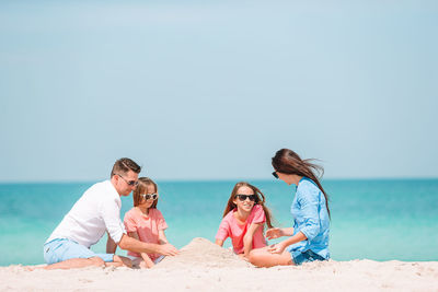 People on beach against clear sky