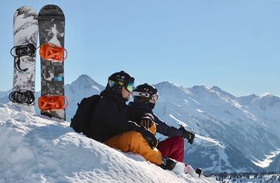 People on snowcapped mountain against sky