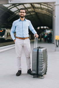 Full length of young man standing at railroad station platform