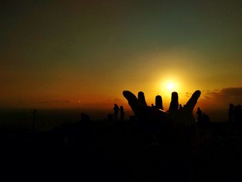 Silhouette people against sky during sunset