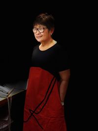 Smiling senior woman wearing eyeglasses standing at home