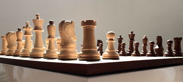 Close-up of chess pieces against gray background