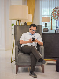 Young man using mobile phone at home