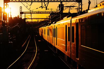 Train at railroad station against sky during sunset