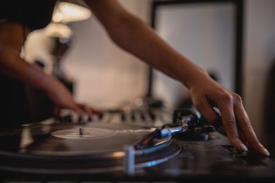 Midsection of woman playing sound mixer at home