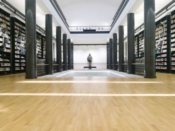 Rear view of man reading book in building