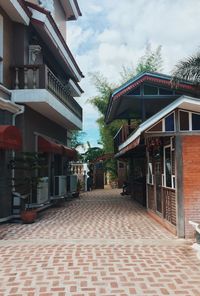 Street amidst houses and buildings against sky