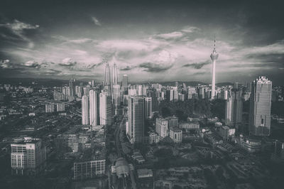 View of cityscape against cloudy sky