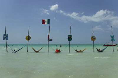 View of boats in sea against cloudy sky