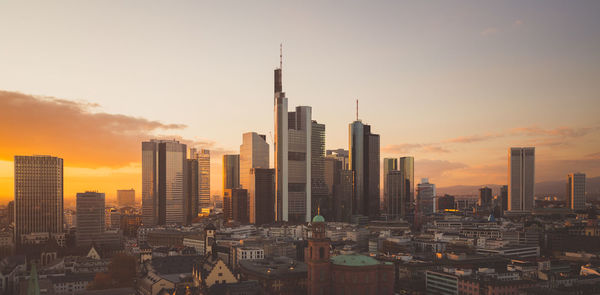 Buildings in city against sky during sunset