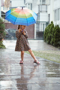 Rear view of woman with umbrella standing in water