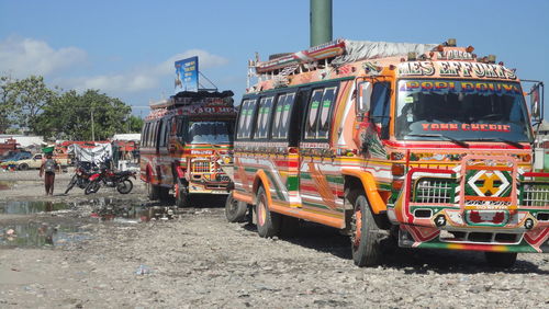 Buses on field against sky