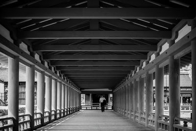 Rear view of people walking on bridge