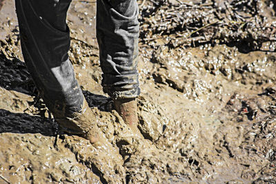 Low section of person standing in mud