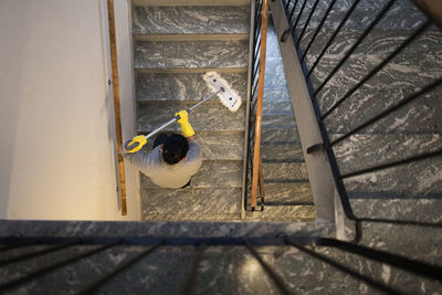 Woman mopping staircase