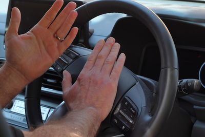 Cropped hands of man driving car