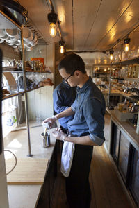 Waiter pouring milk in restaurant kitchen