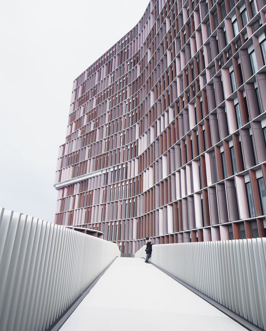 architecture, built structure, building exterior, one person, building, sky, day, nature, full length, low angle view, city, real people, lifestyles, modern, walking, clear sky, office, office building exterior, outdoors