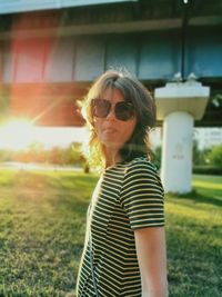 Portrait of young woman wearing sunglasses while standing in park