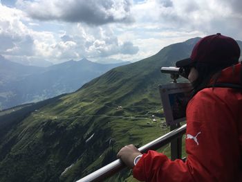 Rear view of man looking at mountain against sky