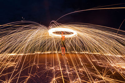 Blurred motion of man with fire crackers at night