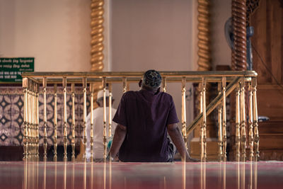 Full length of man sitting on table in building